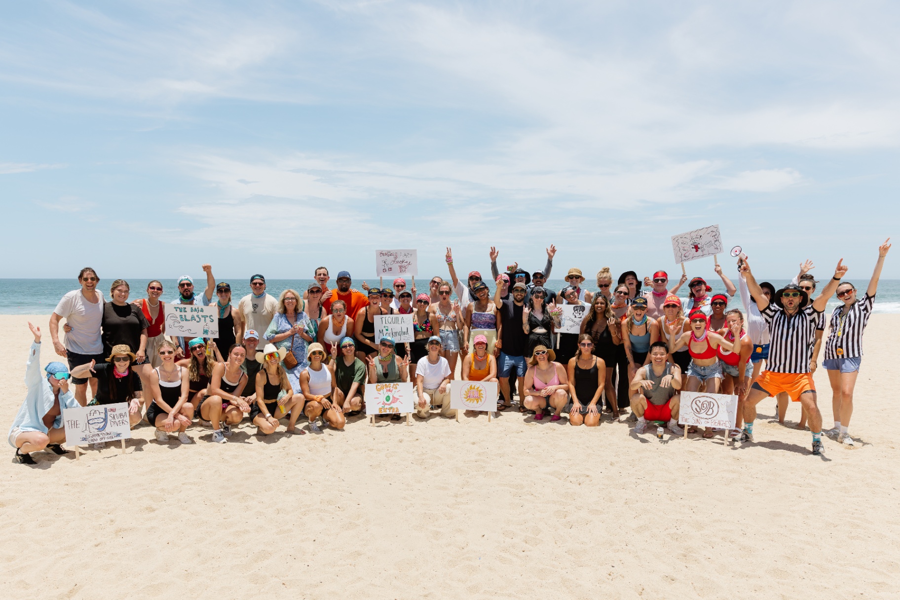 Whitestone teammates and Handstand referees celebrating together on the beach in Cabo