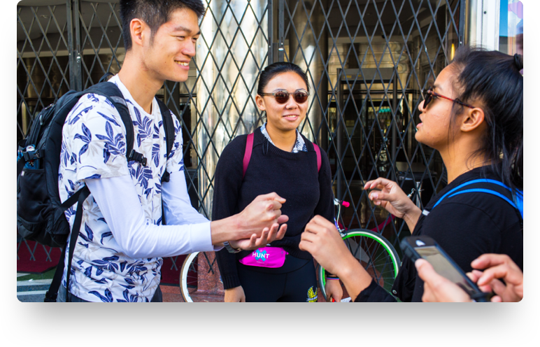 Coworkers playing rock-paper-scissors during a team building scavenger hunt challenge